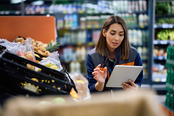 istock Female worker using digital tablet in a supermarket. 2211334991