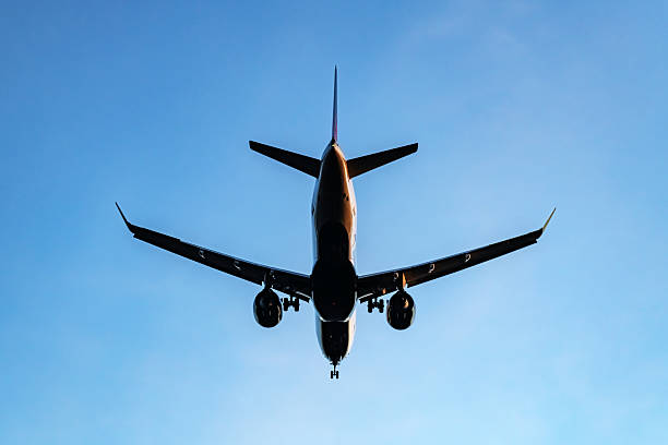 A passenger jet directly above prepares for landing.