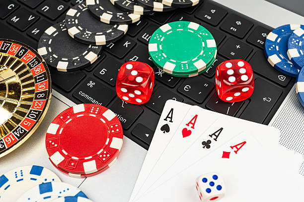 istock A stock image displays various casino items arranged on a white surface, resembling a keyboard layout Items include red chips, dice, playing cards, and slot machine tokens The context suggests gamb 2211346186