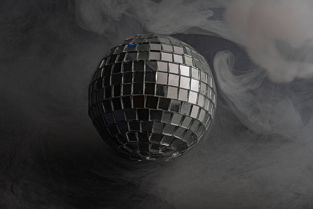 istock A shiny disco ball floats amidst smoke-like background, evoking a lively and nostalgic atmosphere associated with dance halls and parties of the past 2211346192