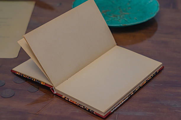 Image features an open notebook on aged wooden surface, symbolizing readiness or potential for use, with themes of planning, storytelling, creativity, vintage, and timeless quality suitable for marke