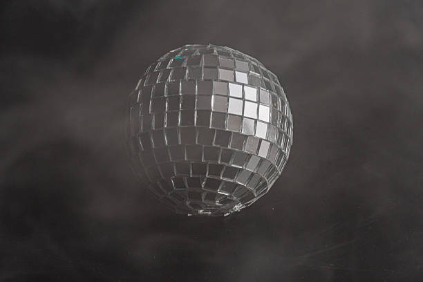 A glittering disco ball against a dramatic black backdrop with smoke, evoking the atmosphere of discos and dance parties Suitable for marketing materials in entertainment, events, retro themes, or f