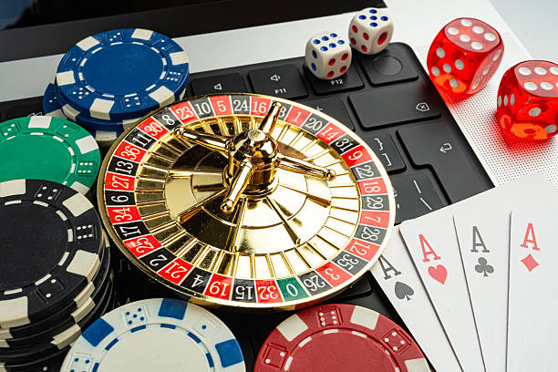 istock Image depicts a gambling scene, centered around a roulette wheel and playing cards, symbolizing casino games like poker or blackjack Scattered chips suggest betting on table games The imagery conve 2211346301