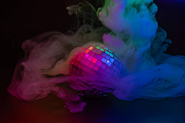 istock Image of a disco ball emitting colorful light beams in a dark environment, creating an effect similar to mist or smoke Conveys fun and celebration 2211346338