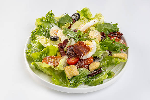 istock Caesar salad on wwhite  plate on white background 2211346419