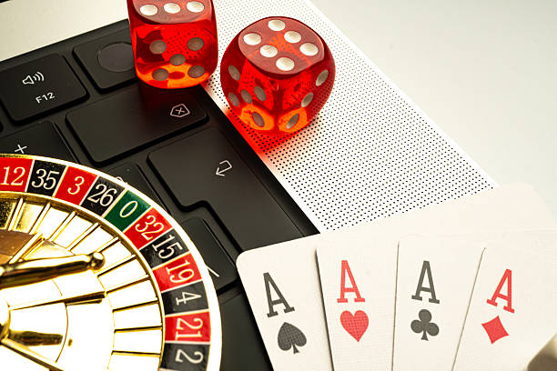istock Image showcases gaming culture, featuring dice, playing cards, and a laptop with webcam, possibly depicting online or virtual gaming The scene suggests themes of luck, chance, and skill relevant to 2211346568