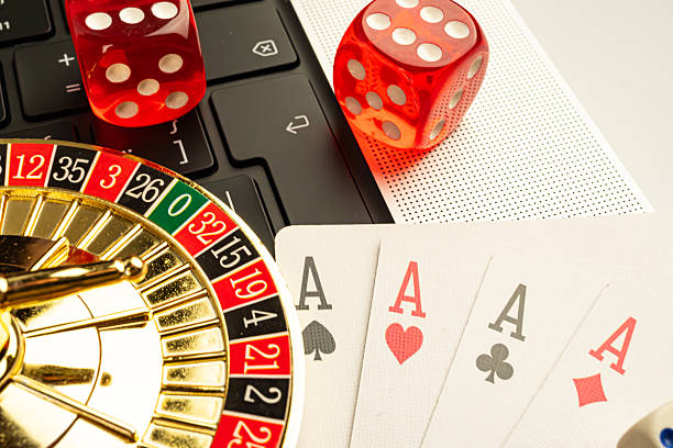 istock Image showcases a composite of casino elements, featuring playing cards spades, dice sixes, roulette wheel, and laptop suggestive of online gambling or gaming 2211346580
