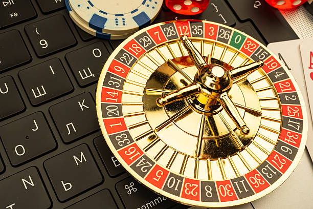 istock Close-up of a roulette wheel on a computer keyboard, with casino chips scattered around, suggesting a blend of traditional gaming and technology 2211346689