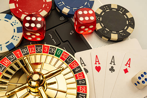 istock Image showcases a casino setting with playing cards, roulette wheel, dice, and neutral backdrop 2211346694