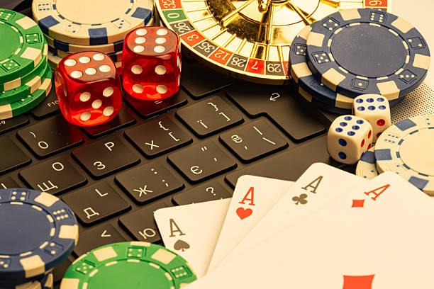 istock Image depicts casino elements, including poker chips, playing cards, and a roulette wheel, possibly suggesting online gambling or gaming activities Laptop keyboard is visible in the foreground 2211346795
