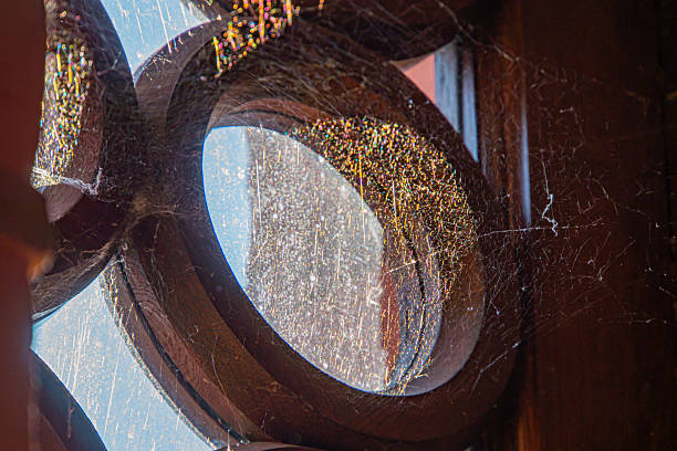 Image showcases an old, intricately designed arched window in a vintage or historic setting The view outside is partially visible through weathered glass No texts are discernible