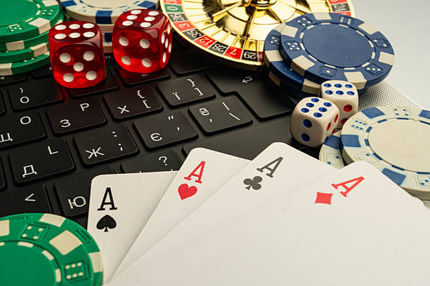 istock A vibrant image showcasing online gaming, featuring a laptop screen displaying poker cards and traditional casino items like chips, dice, and cards Symbolizes the fusion of classic gambling elements 2211346855