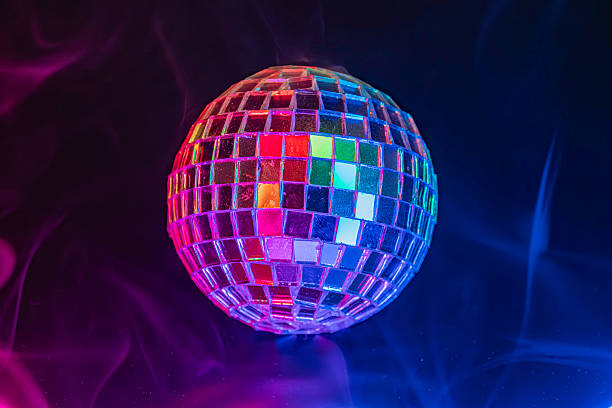 istock Disco ball floating in a dark, smoke-filled background with vibrant lights Commonly associated with party scenes, events like parties, concerts, nightclubs, or music and entertainment 2211346901