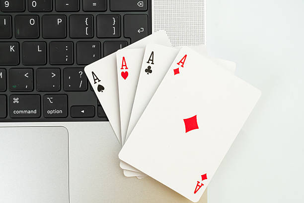 istock A creative image showcasing playing cards on a laptop keyboard, suggesting themes of technology, digital gaming, strategy, online gamblinge-sports, and pressure decision-making 2211346982