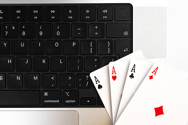 istock A black computer keyboard with white lettering is next to a spread of playing cards, suggesting a break from technology for leisure card games 2211347038