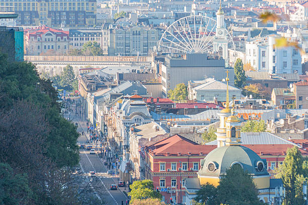 The image showcases San Franciscos Painted Ladies from an elevated perspective, blending history with modern city life, framed by greenery and a majestic Ferris wheel It captures the unique charm a