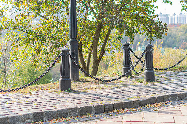 istock A tranquil image of a historic stone pathway leading to a wrought-iron gate, surrounded by lush greenery and set against warm brick tones The low-angle perspective invites exploration and hints at s 2211348423