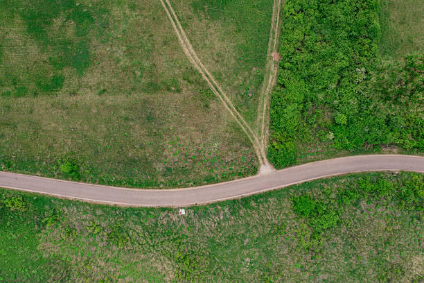 istock Curving countryside road through grassy and dry terrain 2211348827