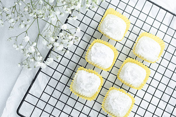 istock Delicious yellow pastries with white icing arranged on a cooling rack 2211349071