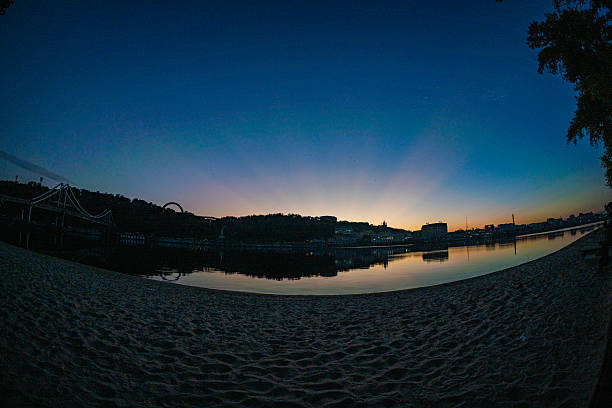 A stunning time-lapse photograph captures a serene beach scene transitioning from day to night, showcasing the beauty of nature and providing a sense of peace