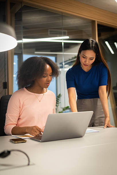istock Young Black and Asian Businesswomen Collaborating in Modern Office Setting 2211349341