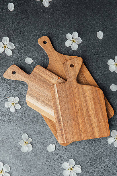 istock Wooden cutting boards arranged on a dark surface with flowers 2211349485