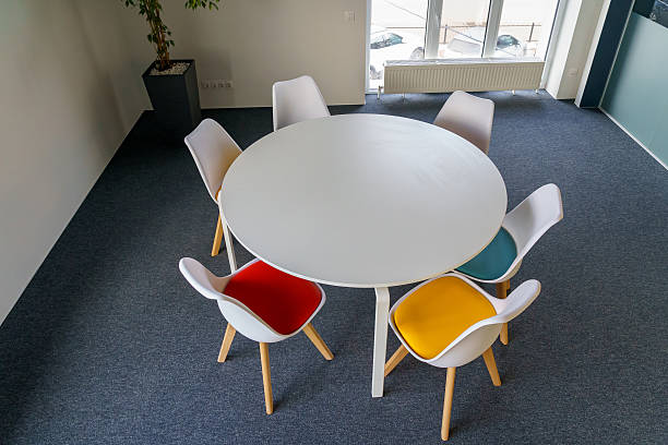 istock Modern meeting area with round table and colorful chairs 2211352123