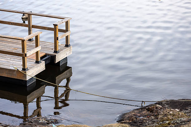 Peaceful view featuring a wooden dock extending into calm waters with reflecting surface. Emphasizes tranquility, nature, and serene outdoor settings, capturing the relationship between human-made structures and natural environments.