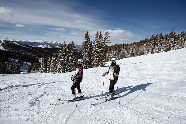 A serene winter scene featuring a snow-covered trail winding through dense pine trees blanketed in fresh snow. The peaceful and pristine natural setting evokes a sense of calm and tranquility, perfect for outdoor enthusiasts and nature lovers. Ideal for seasonal, travel, and outdoor adventure themes, this image captures the beauty of winter in a mountainous forest environment.