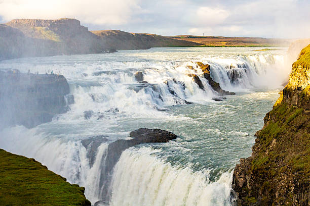 istock Stunning Icelandic Waterfall Cascading Amid Rugged Landscape in Golden Hour Light 2211354936