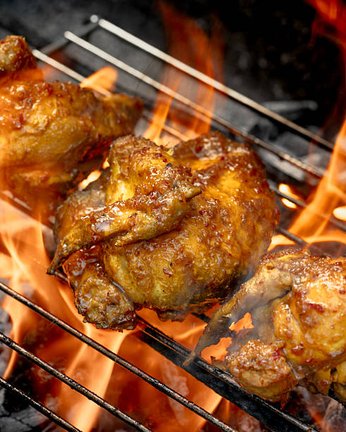 istock Three pieces of chicken are on a grill, with one piece being the largest 2211357314