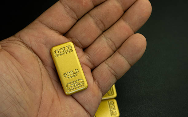 istock Gold bars 99.99% in hand on a black background 2211372850