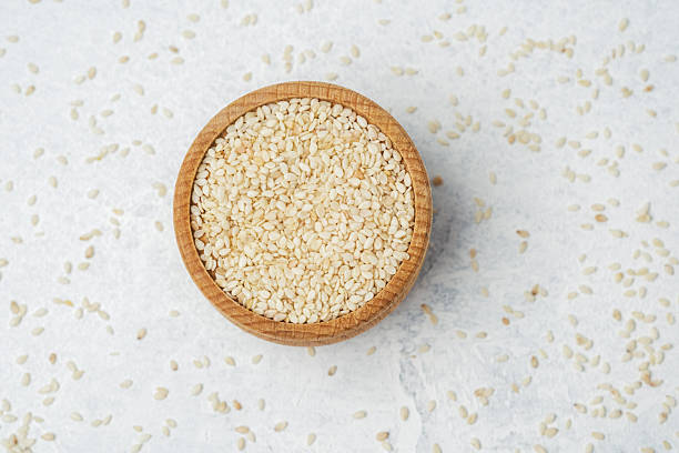istock Natural sesame seeds placed in a wooden bowl on a light surface 2211380107