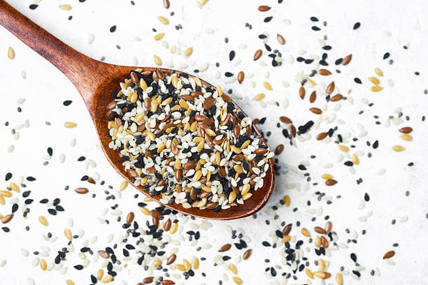 istock Different types of seeds displayed in a wooden spoon on a light background 2211380120