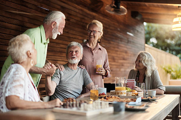 istock Happy seniors talking at picnic table on a patio. 2211382470