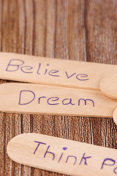 istock Simple composition of motivational sticks with engraved inspirational words arranged on top of a wooden table 2211382670