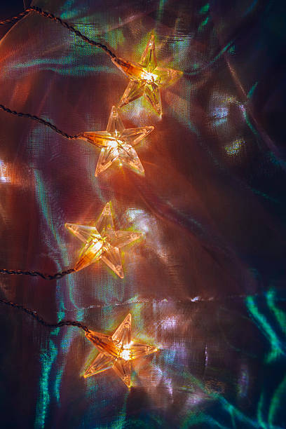 istock Star-Shaped Fairy Lights on Fabric Background 2211383814