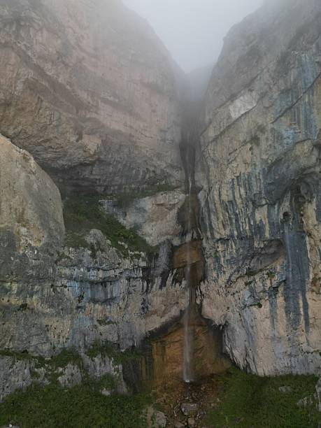 Waterfall cascading down rocky cliff in natural landscape