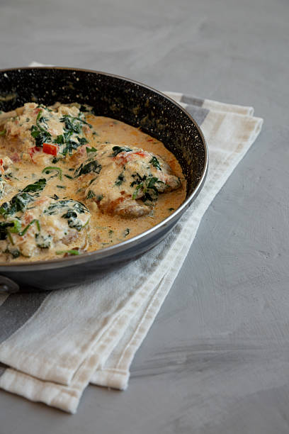 istock Homemade Creamy Tuscan Chicken with Spinach in a Pan, low angle view. Copy space. 2211385222