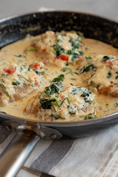 istock Homemade Creamy Tuscan Chicken with Spinach in a Pan, low angle view. Close-up. 2211385225