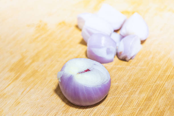 Shelled pearl mini onions placed on a kitchen chopping board, ready for Chinese sizzling chicken wings