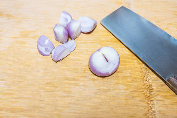 Shelled pearl mini onions placed on a kitchen chopping board, ready for Chinese sizzling chicken wings
