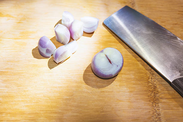 Shelled pearl mini onions placed on a kitchen chopping board, ready for Chinese sizzling chicken wings
