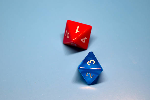 Two four-sided dice (d4) lie on a solid blue background. One die is bright red with white numbers \