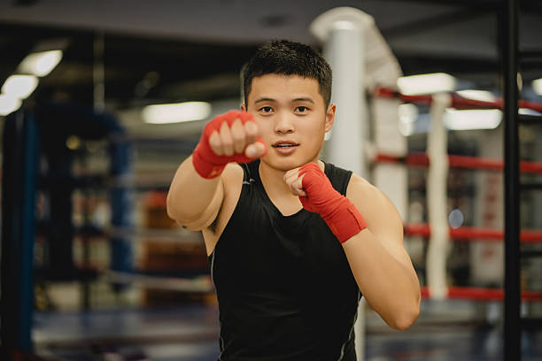 istock The young Asian boxer is looking at the camera on the boxing ring 2211389027