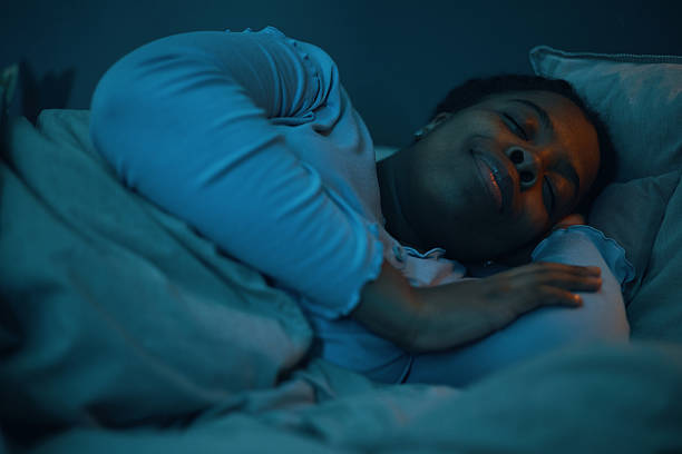 istock Sleeping African American Woman Smiling Peacefully on Pillow 2211389332