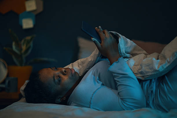 istock Using Smartphone in Bed at Nighttime in Cozy Room 2211389405