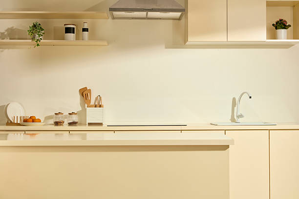 istock Modern and fully equipped kitchen with large counter and long dining table. Kitchen utensils such as plates, spice jars, ladles, range hood are fully prepared. Clean space, full of daylight. 2211390402