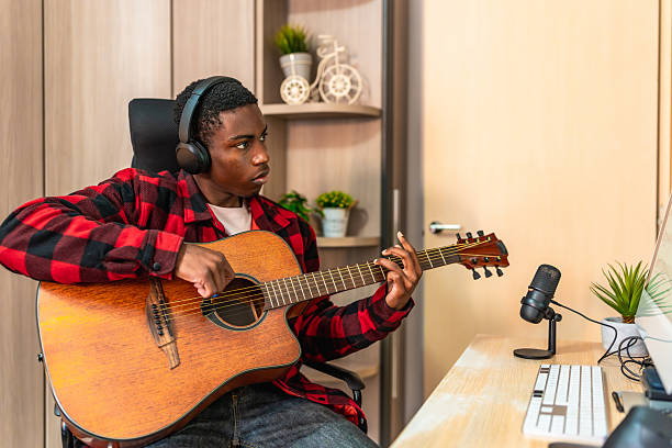 istock Young musician composing music with acoustic guitar and computer 2211391008