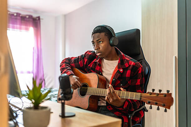istock Young musician composing music with acoustic guitar at home studio 2211391011
